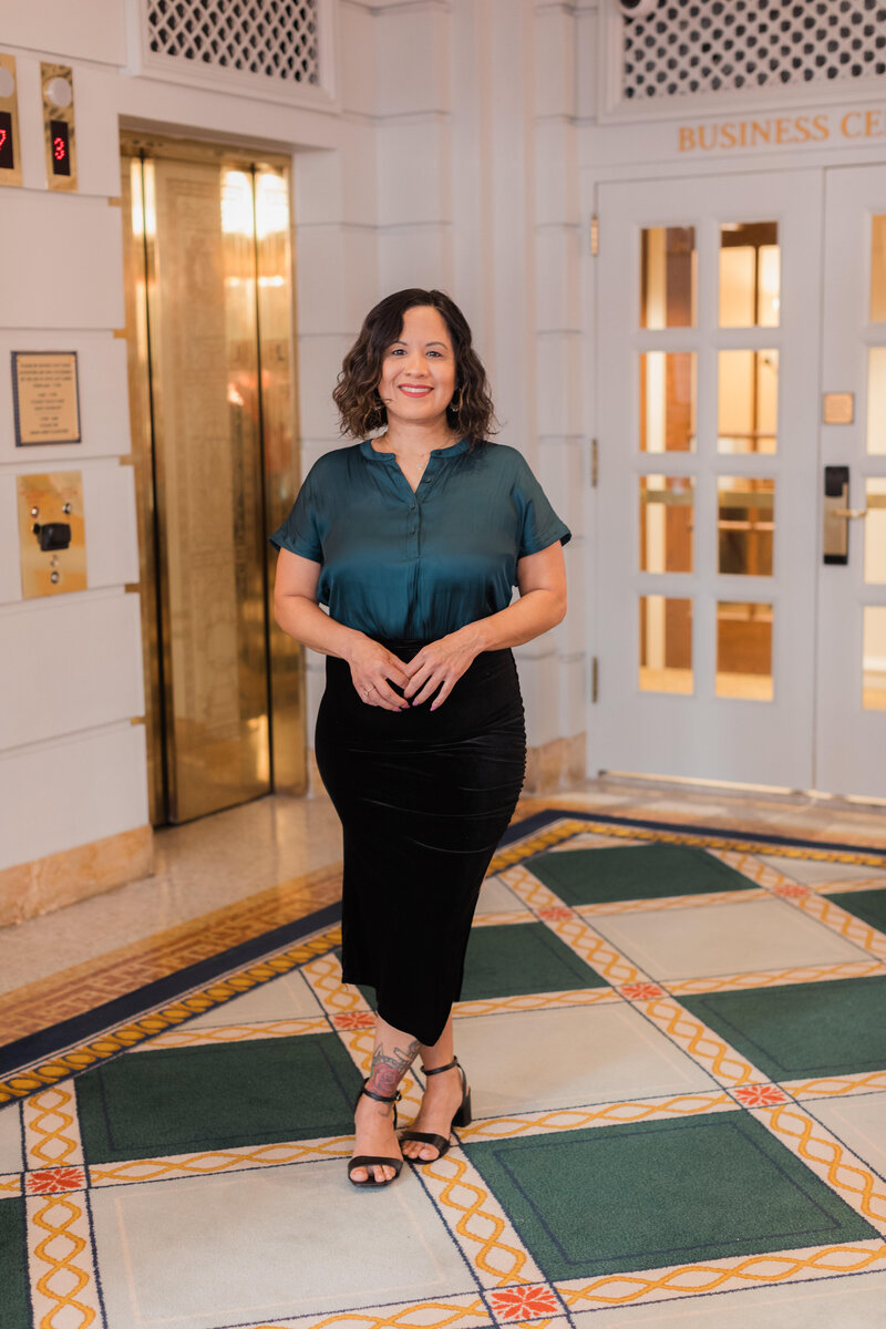 woman posing in a hotel lobby in fron of elevator