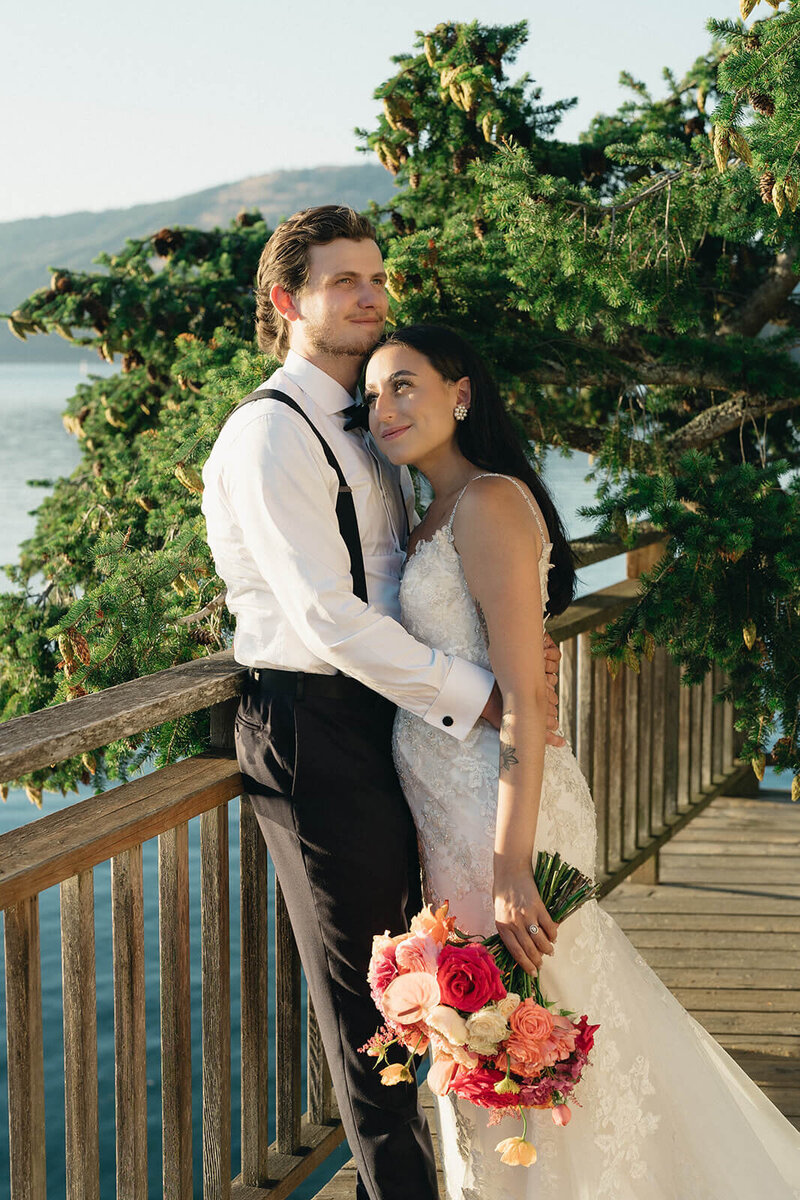 Bride leaning on groom, holding bouquet