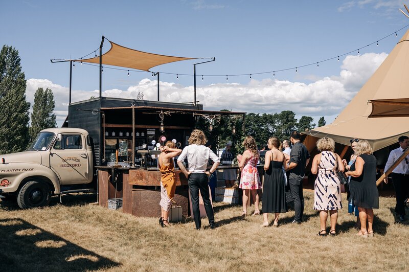 base food by fire two-storey bar set up beside tipis at a vineyard wedding in christchurch