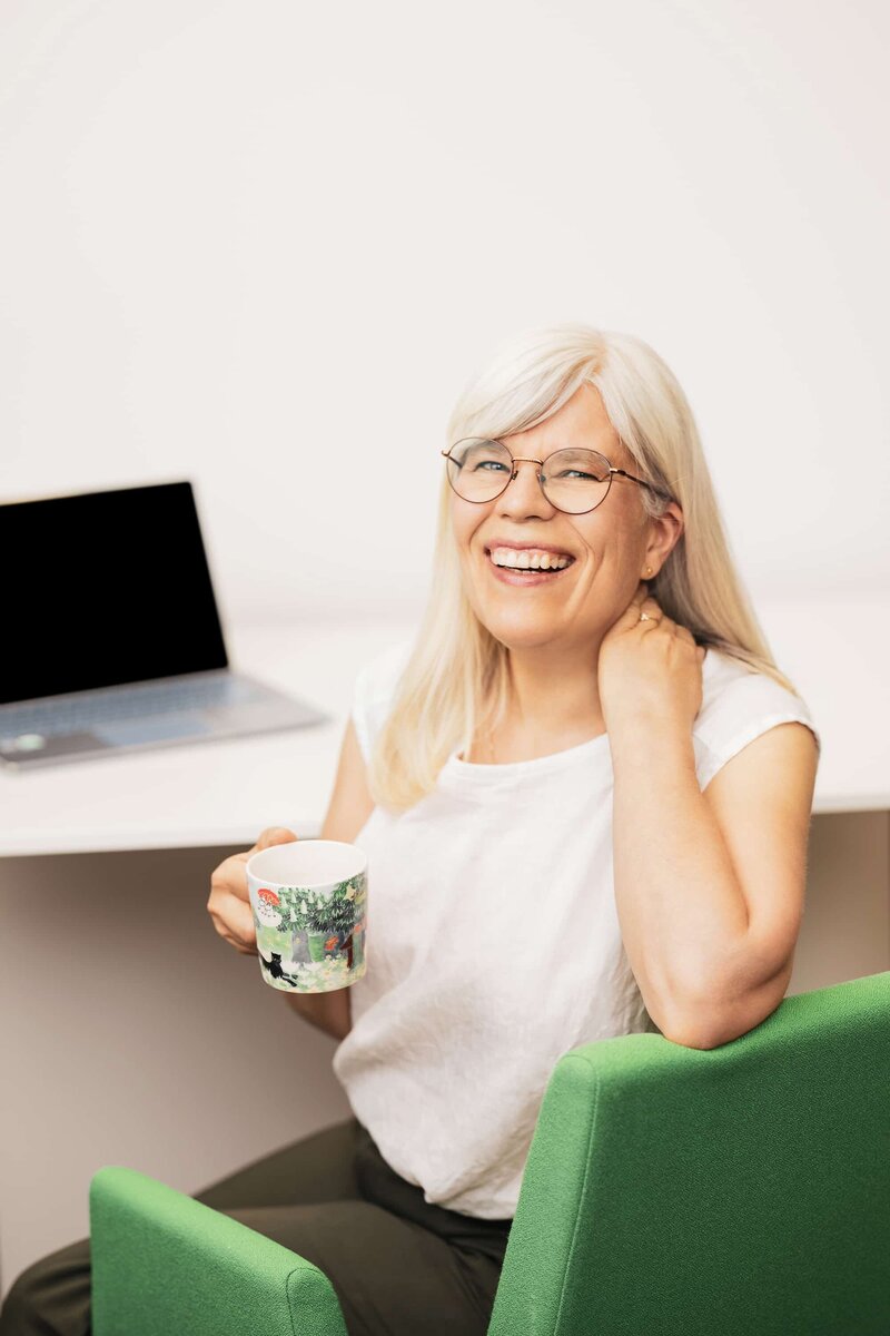 women smiling while sitting at her desk