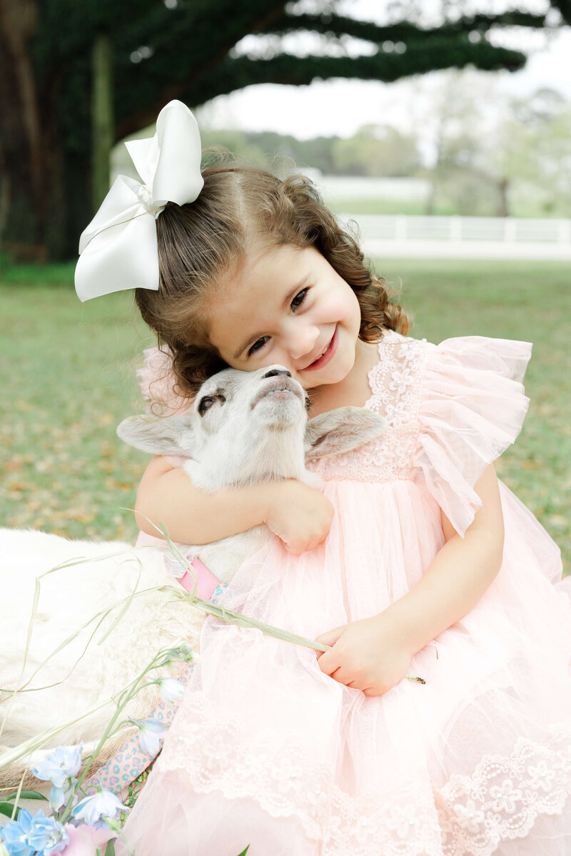 Girl hugs a lamb during lamb mini session