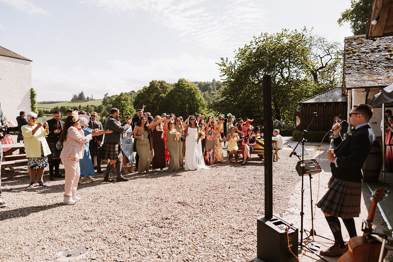 bride and bridal party in silk gowns sitting in bath drinking champagne fun alternative wedding photographer scotland