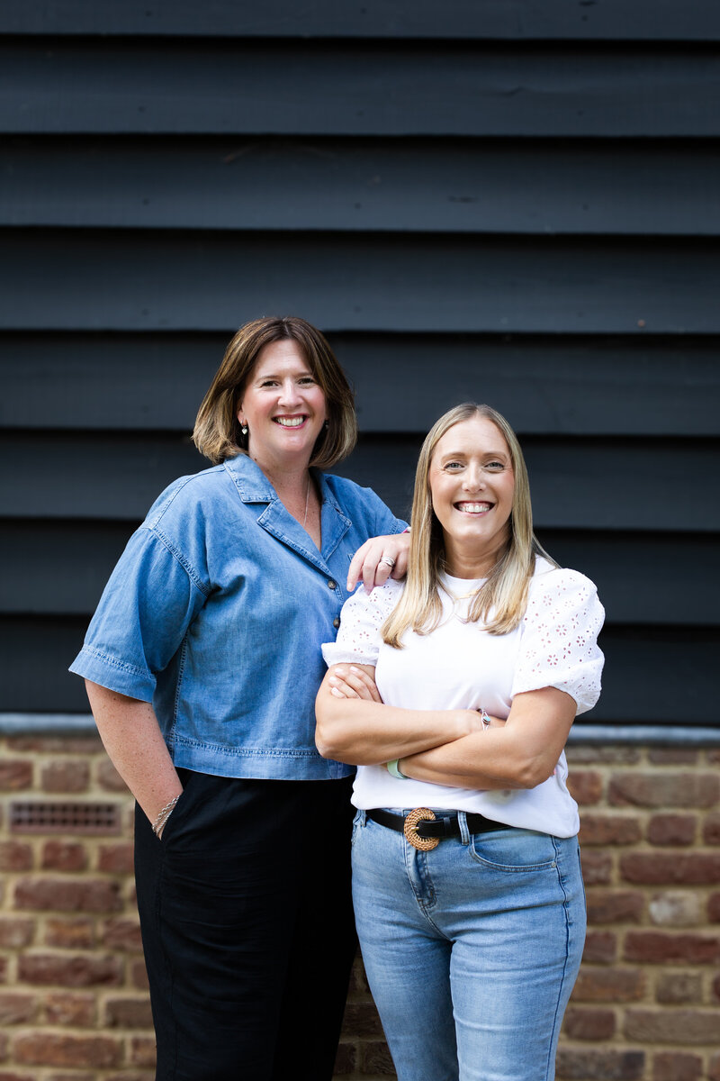 the two lauras are sitting on some outdoor steps with a building behind them