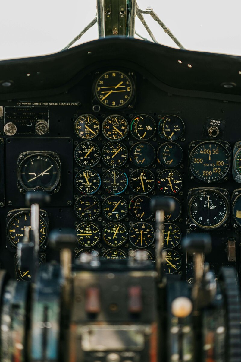 Close-up of an airplane cockpit dashboard filled with numerous analog gauges and dials, representing aviation technology and precision control.