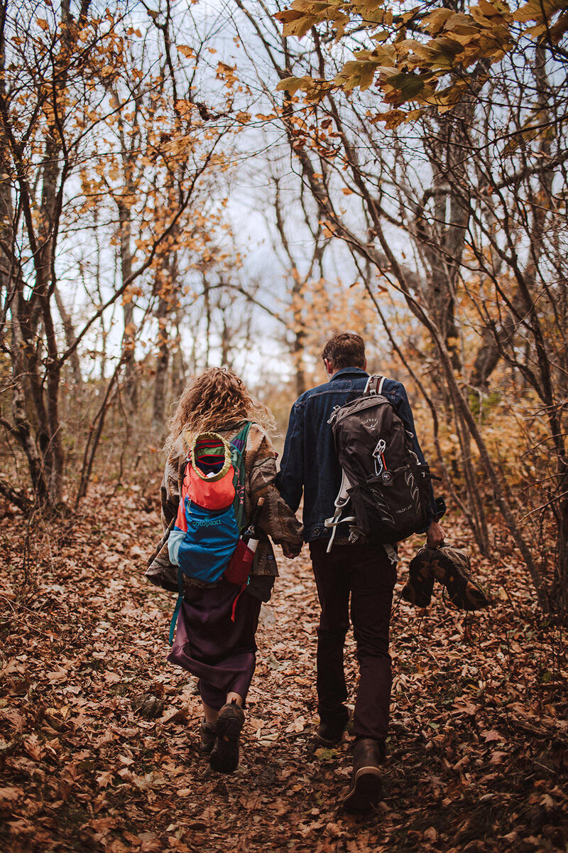 couple walking on fall leaf path