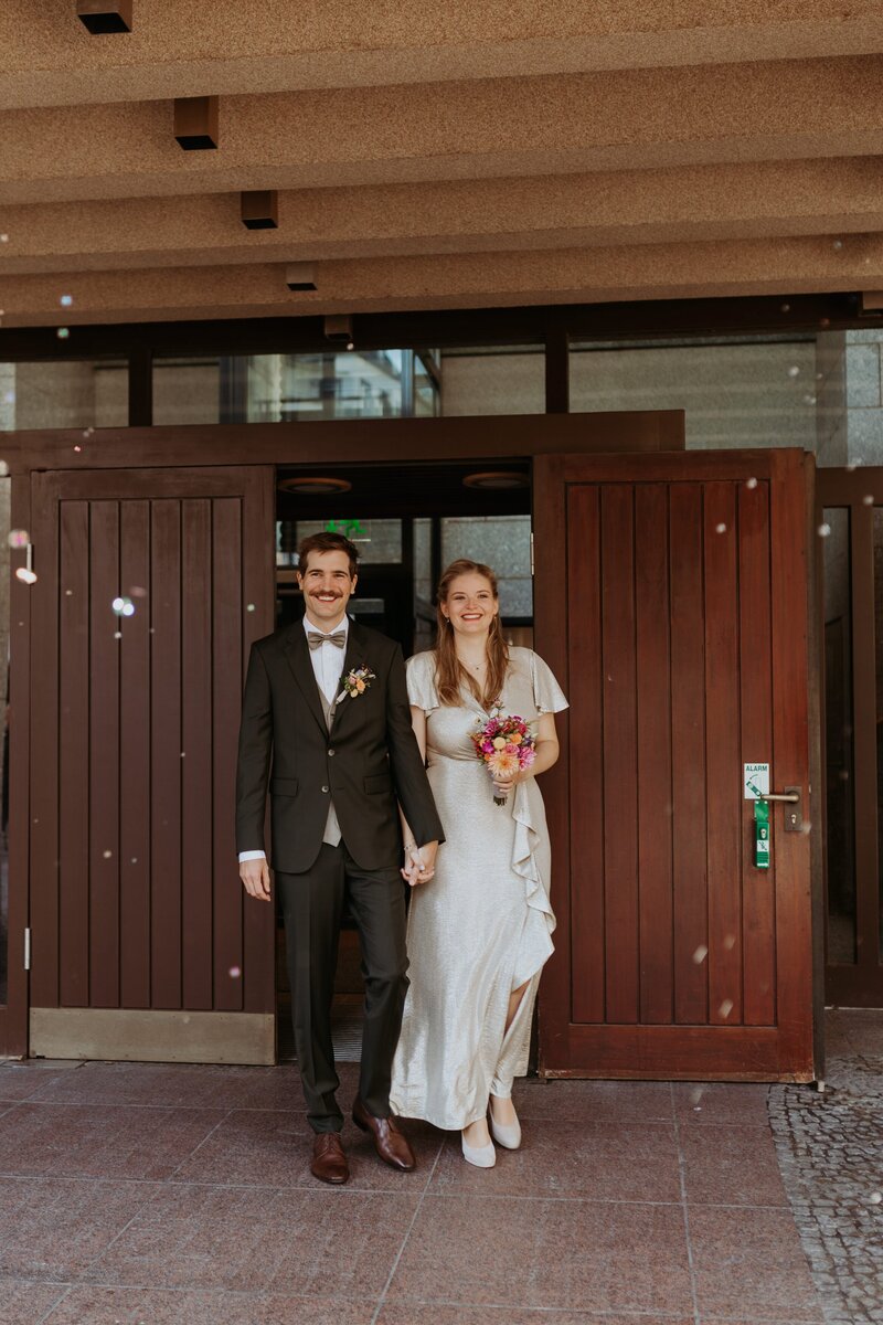 Hochzeitspaar kommt aus dem Standesamt Köln gelaufen 