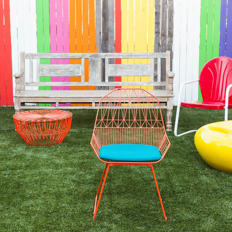 Colorful patio chairs and benches on green turf