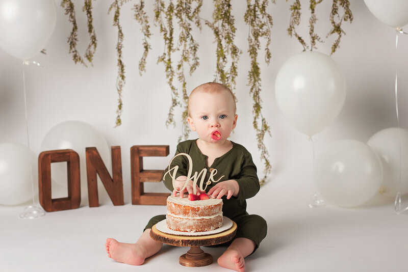 First birthday boy nacked smash cake neutral backdrop white balloons