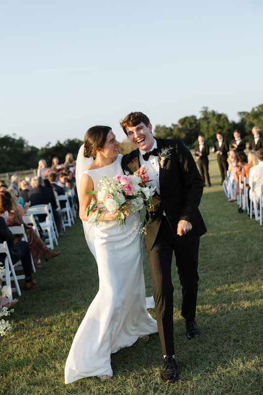 Couple looks at each other after walking down the ceremony aisle