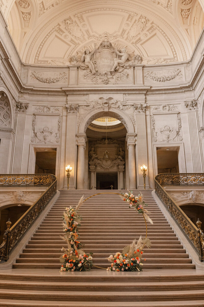 Grand staircase with floral wedding arch at ceremony site