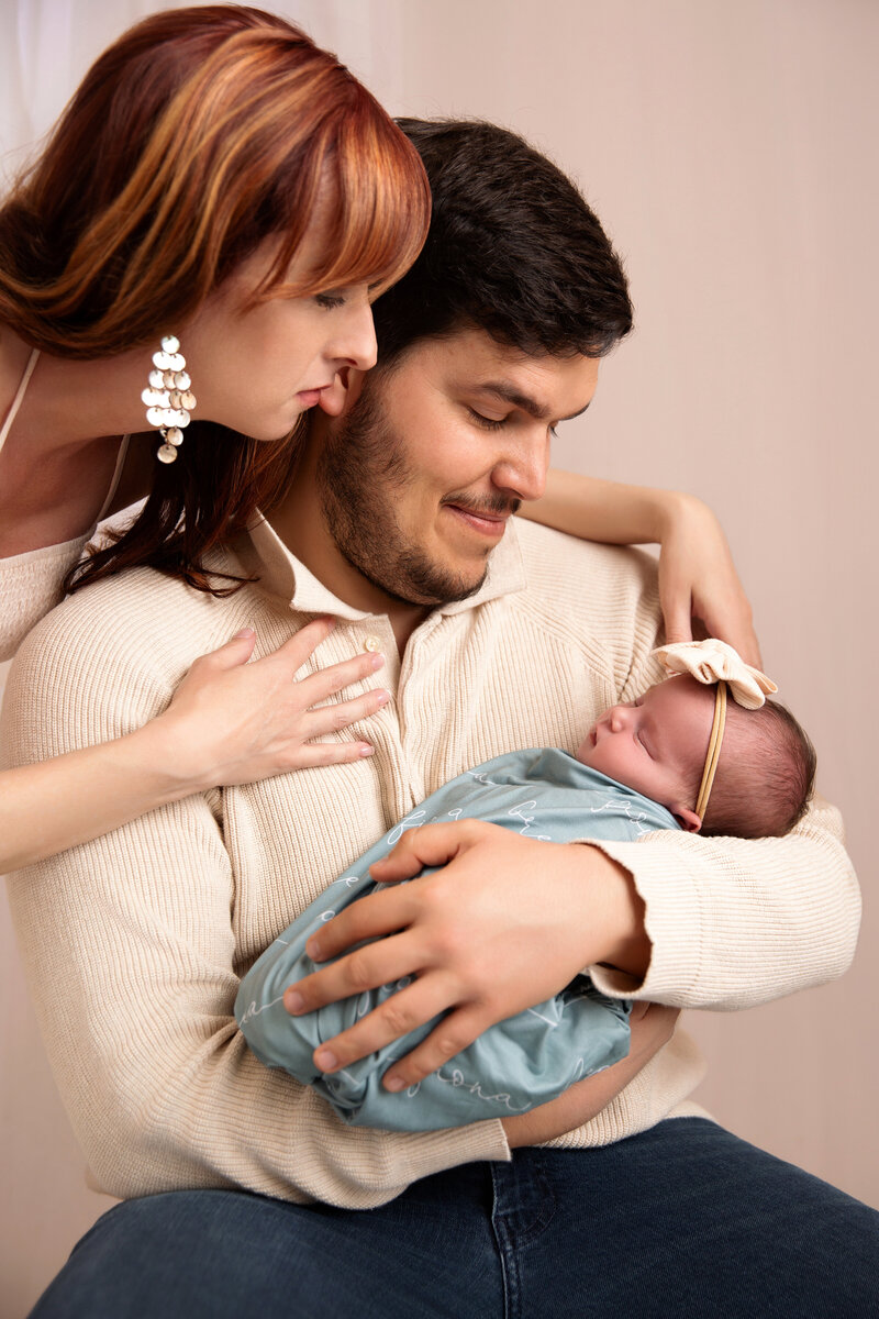 Family smiling and laughing with toddler.  Mother with baby bump.