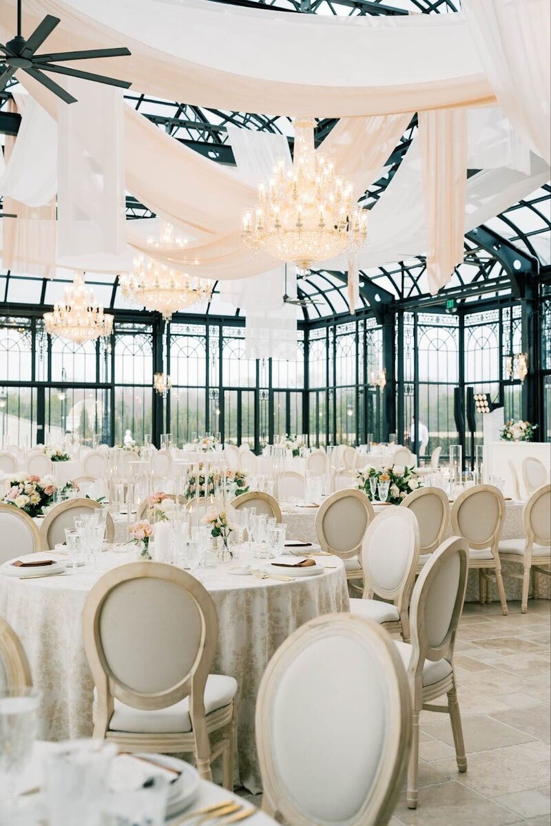 bride and groom kissing at their bridal party tosses flower pedals standing in from of a beautiful pergola decorated with flowers by wedding planners in Cleveland Ohio, Sirpilla Soirees