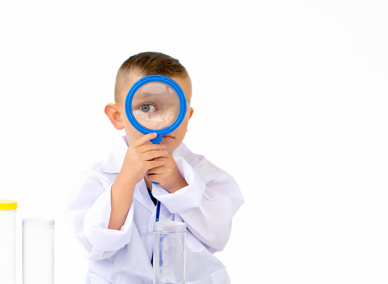 Littleboy looking through a magnifying glass for this scientist birthday session