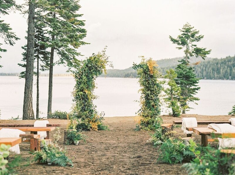 Wedding Ceremony with asymmetric floral arch and bench next to Lake Tahoe, California
