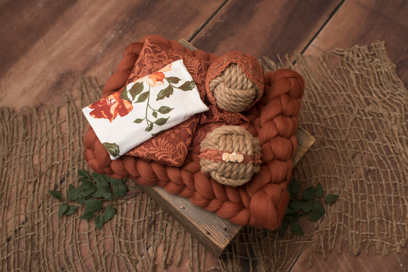 Fall floral design on wrap, lace wrap, burnt orange backdrop, bonnet and headband on crate