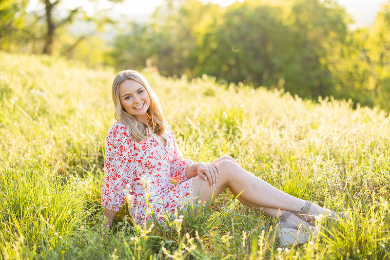 Girl sitting in grass for outdoor senior portrait in Birmingham