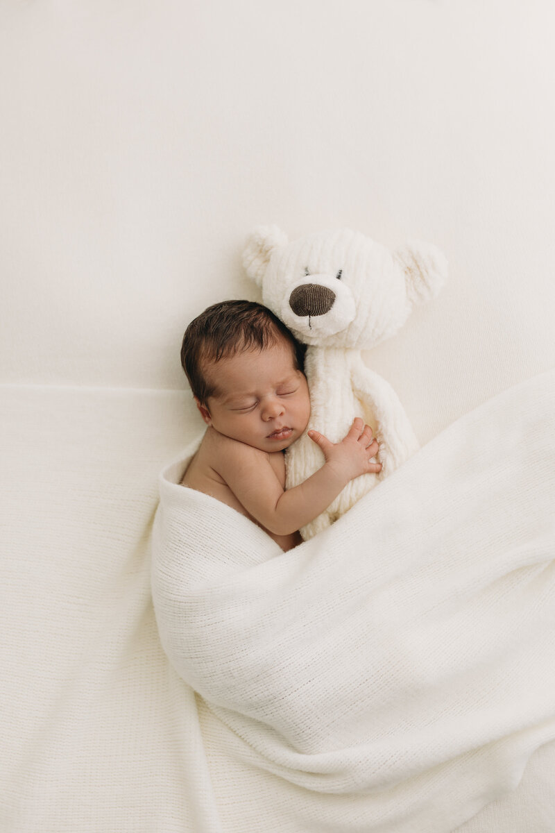 Newborn in studio session with baby sleeping on a pillow in Kelowna B.C wearing neutral clothes