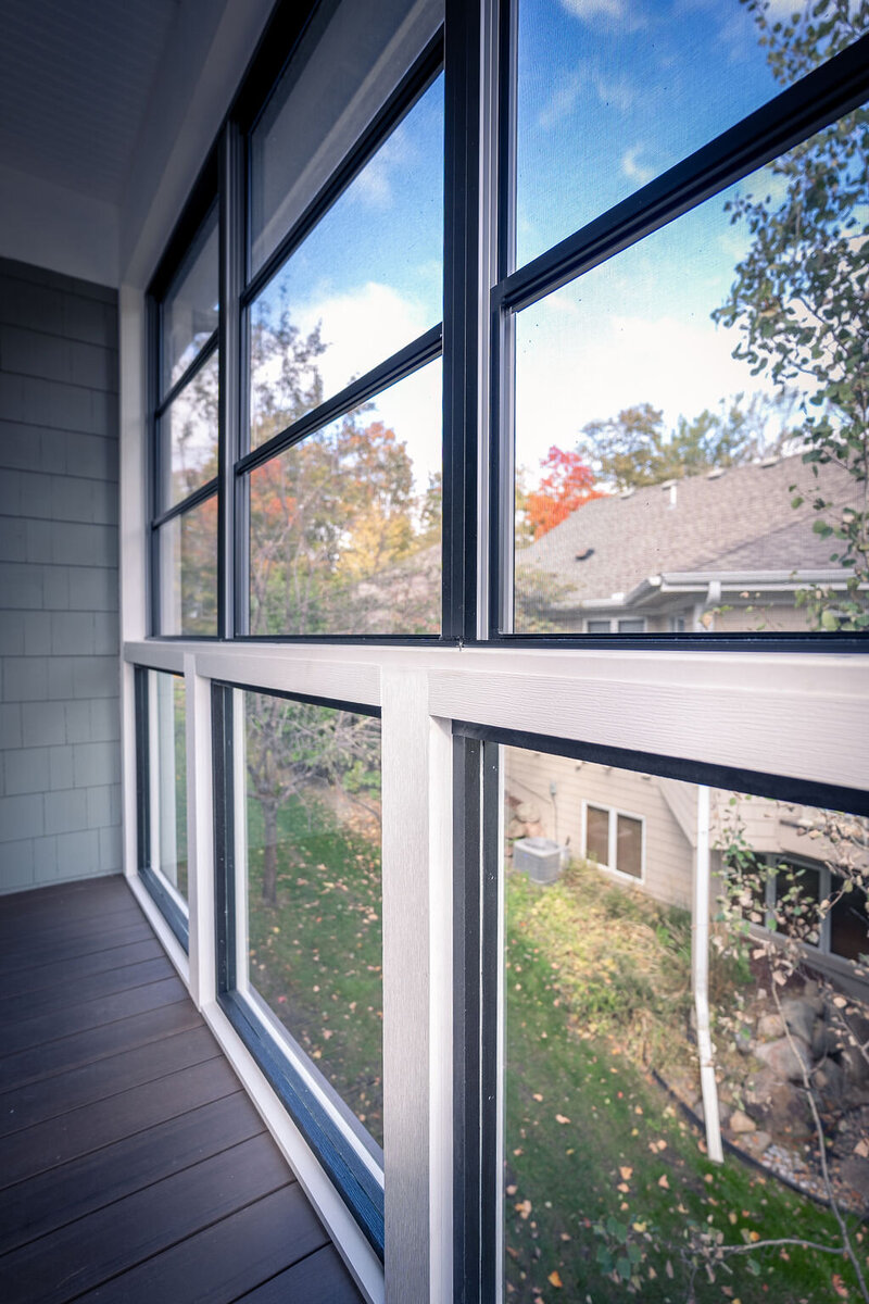 Three-season room wall with custom glass panels on the bottom and vinyl windows on the top. 