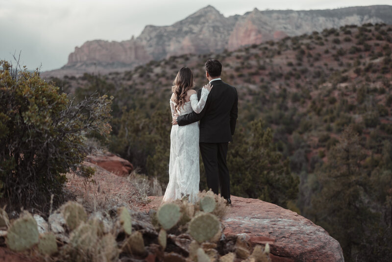 A photo of a bride and groom standing in Sedona red rocks for their elopement. Photo taken by Kollar photography Arizona Elopement Photographer