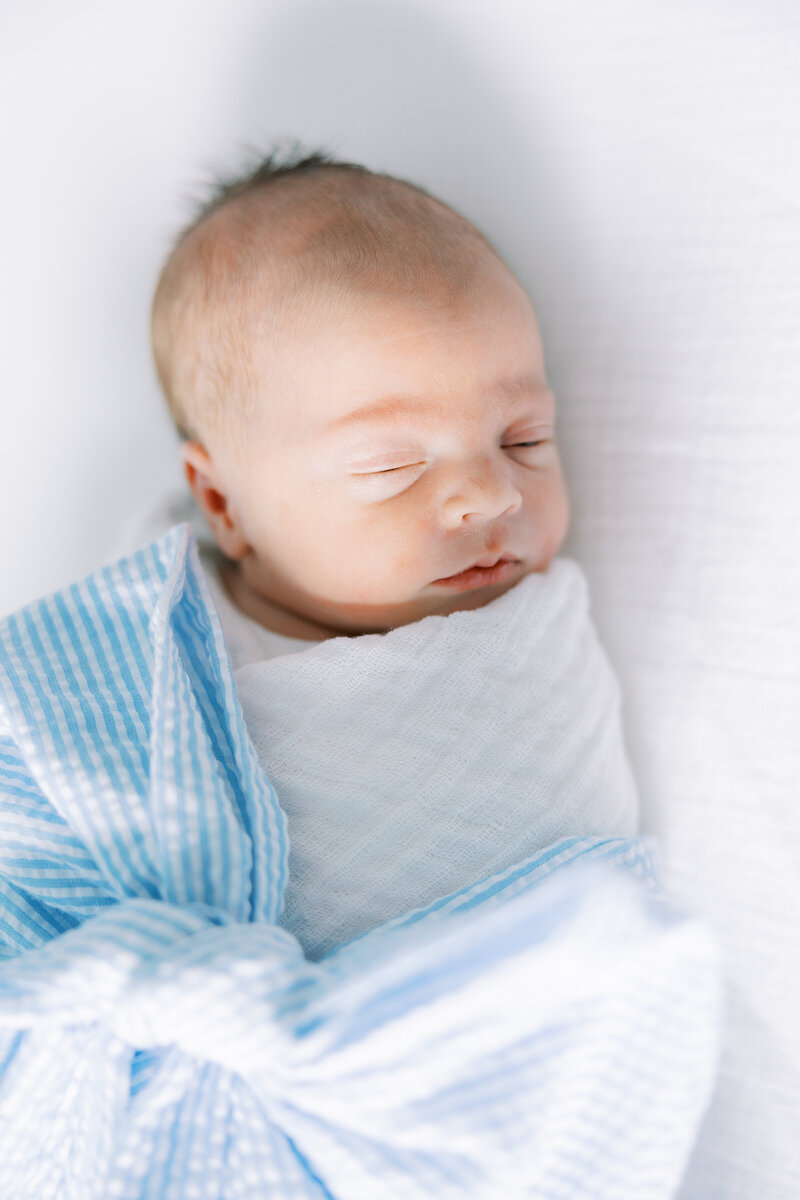 close up photo of baby boy wrapped in searsucker bow during newborn session