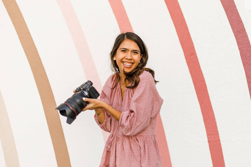 photographer holding camera and smiling at the camera