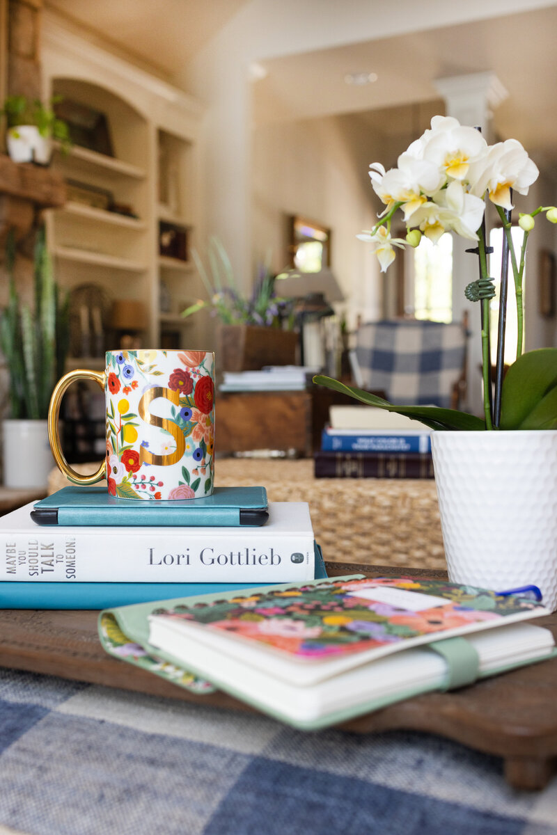 Therapy books and coffee mug sitting on a living room ottoman