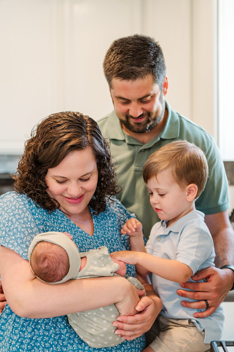 family standing in kitchen at home lifestyle by newborn photography baltimore md