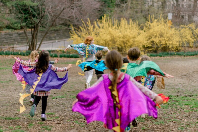Kisd dressed up as dragons running outdoors for birthday party