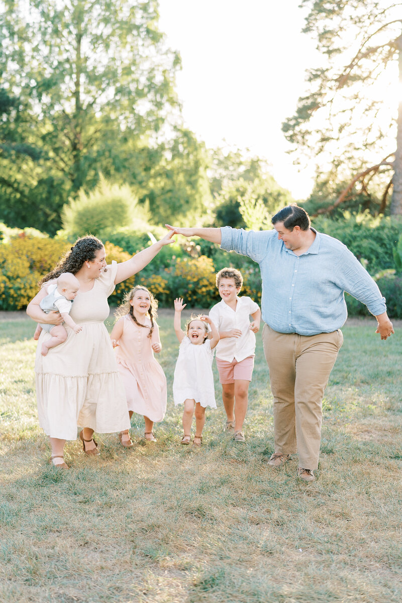 Fine art Catholic wedding photographers Laura and Matthew Schaefer walking with their children on the beach