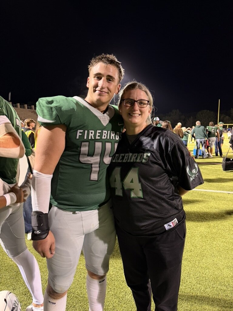 Photographer Megan sitting with her son at an outdoor event, both wearing sunglasses | Senior Photographer in Lawrence, KS