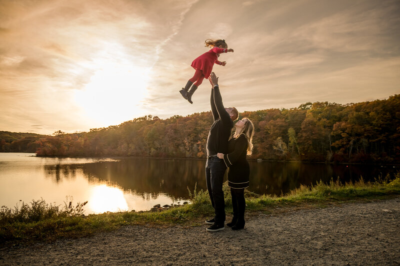 father tossing daughter into air
