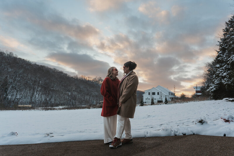 Two women stand in the yard of a large Tennessee house on the day of their LGBTQ elopement 