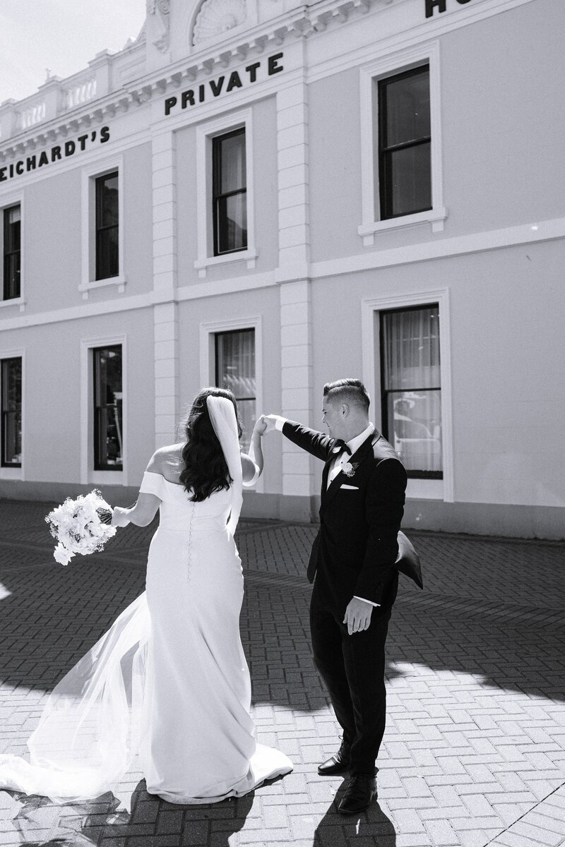 bride twirls outside eichardts luxury hotel in queenstown