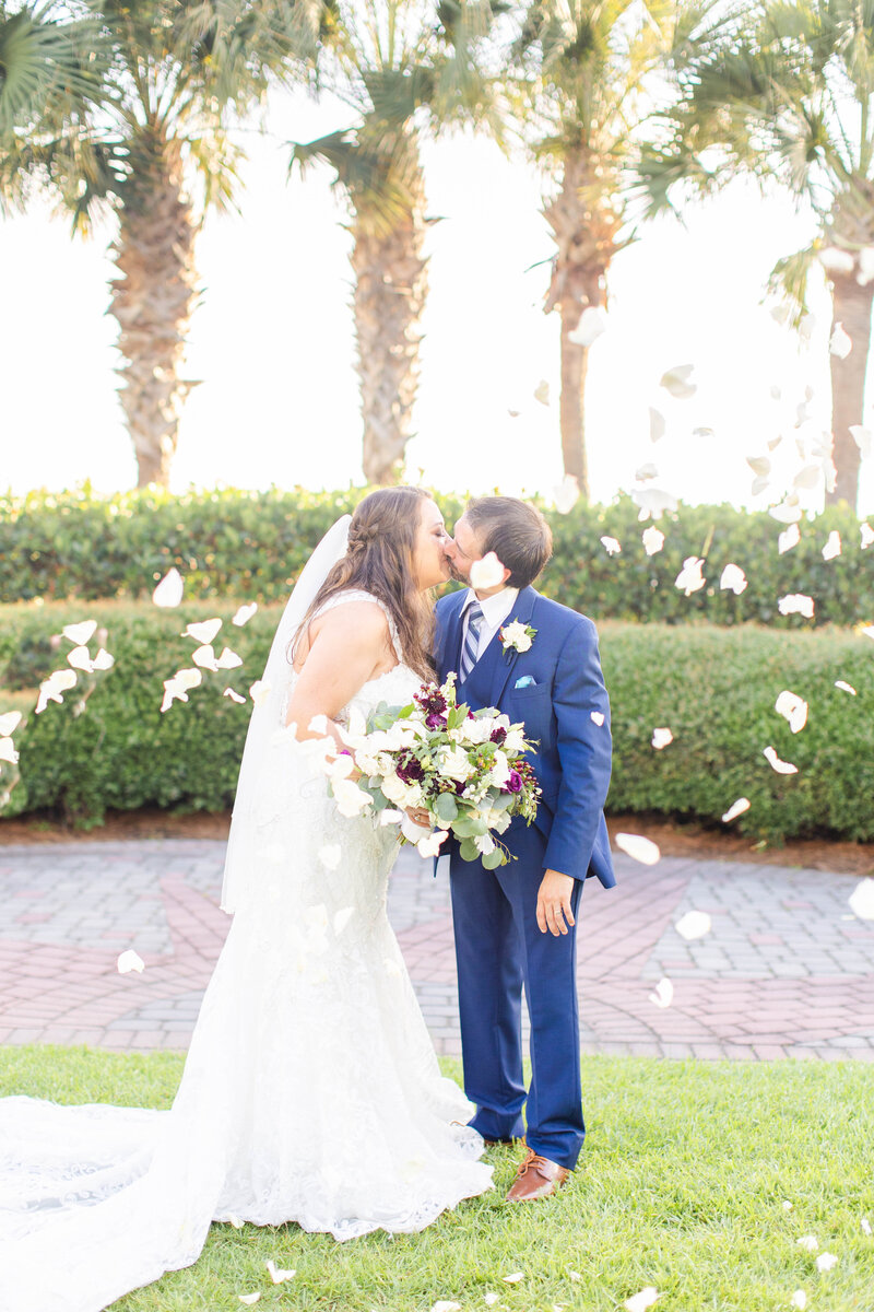 bride and groom facing each other with palm trees behind them
