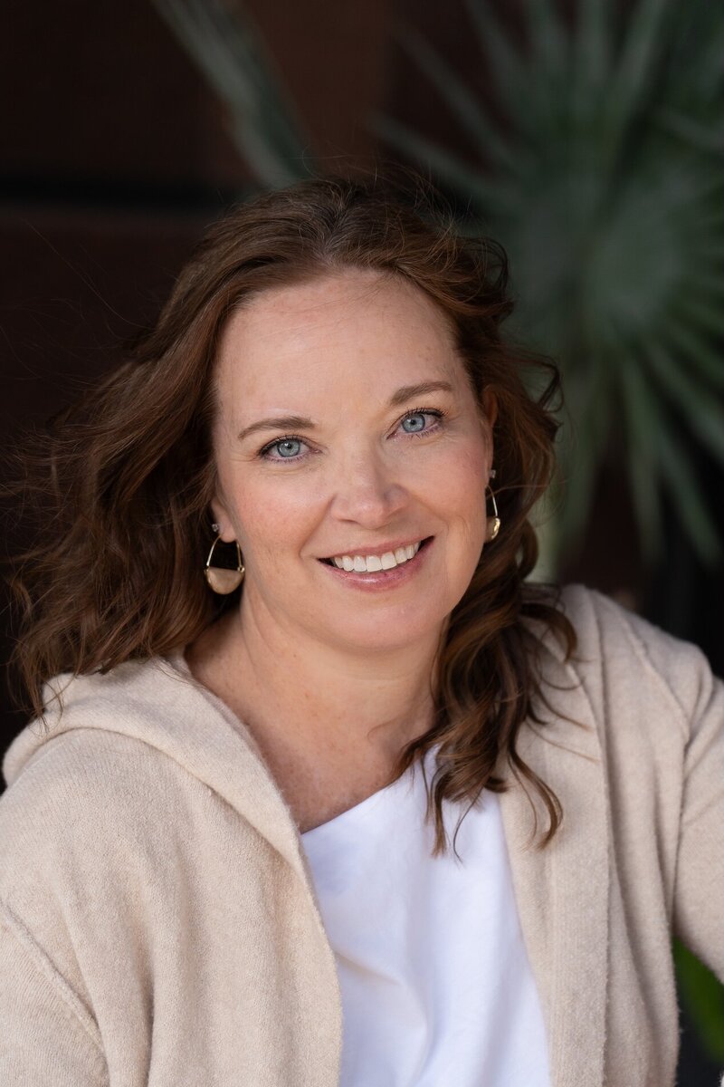 woman with blue eyes and brown hair smiling at the camera