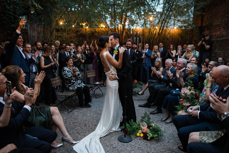 Bride and groom sitting at an empty bar drinking together