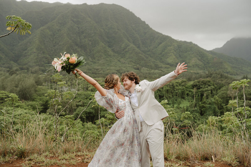 A couple celebrates after their elopement ceremony on a mountaintop in Hawaii.