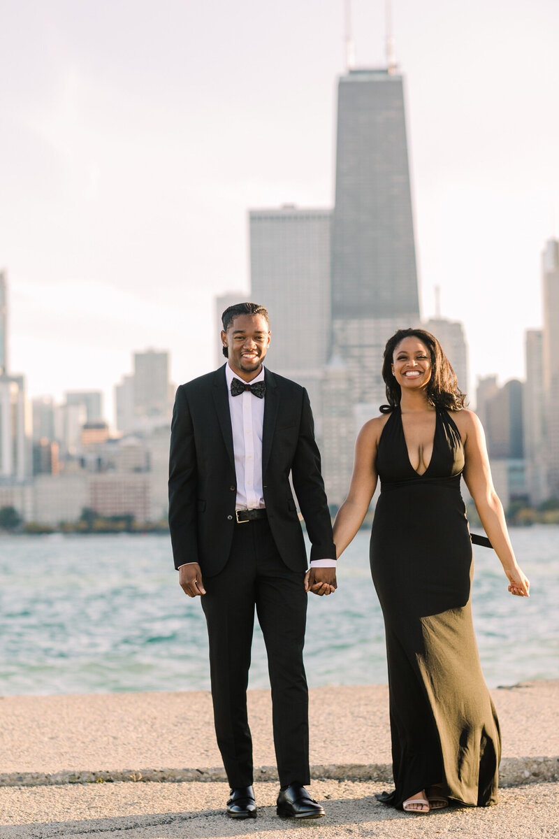 An African American couple pose for an engagement photo in front of the Chicago skyline