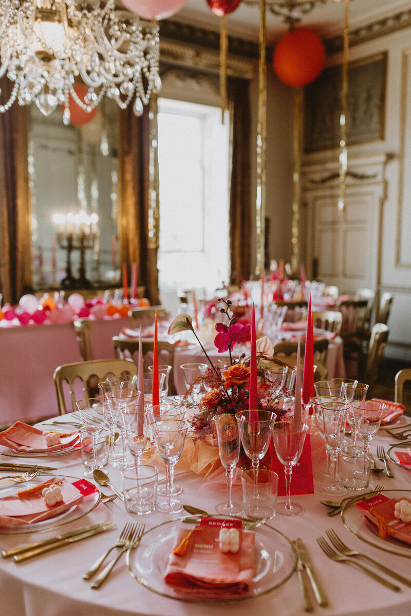 Pink, red, and gold wedding table setting inside Came House