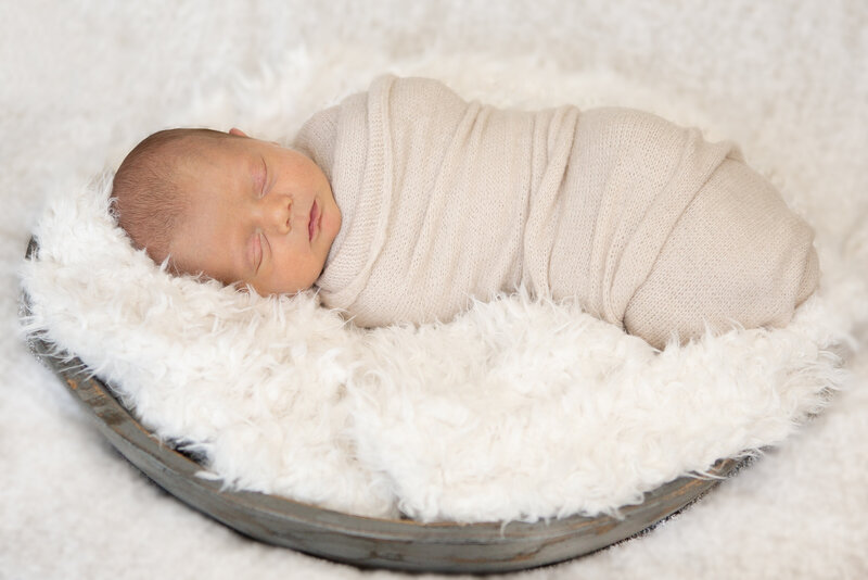 Newborn boy posed in a bowl with Ron Schroll Photography in Charlotte, NC