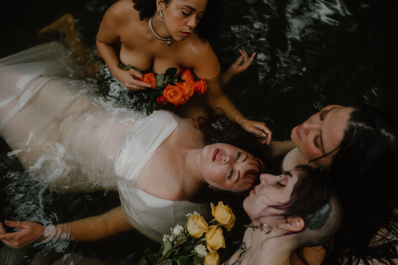 four water nymphs with flowers in a dark enchanted pool