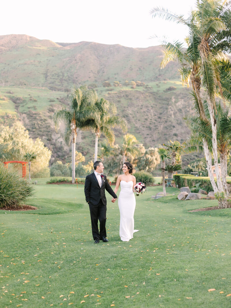 wedding portrait of bride and groom walking on golf course in san bernardino county