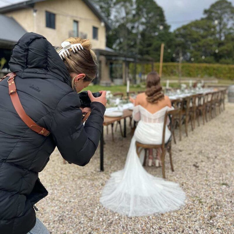 Photographer taking photo of bride sitting on chair