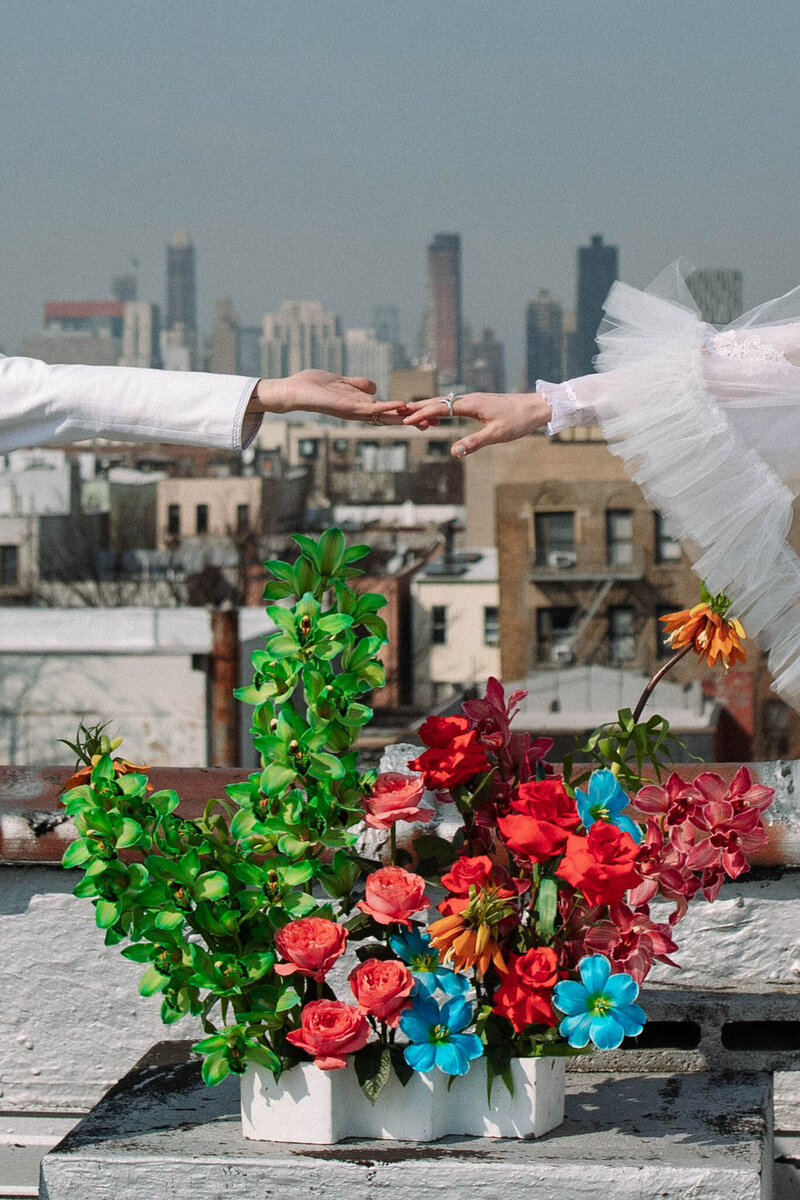 NYC rooftop wedding two brides wearing white suit and white madison chamberlain sweetheart veil and east olivia lime green floral arrangement
