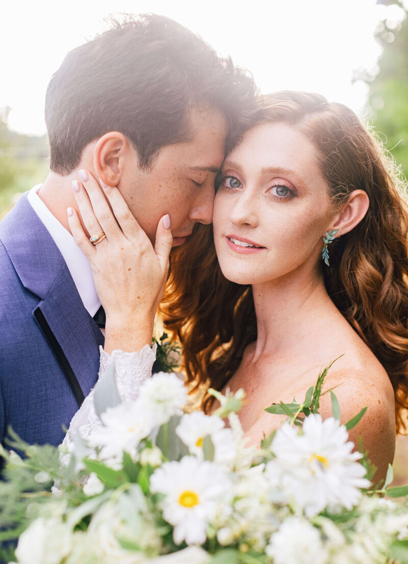 a bride and groom's faces with the bride' s hand on the grooms cheek