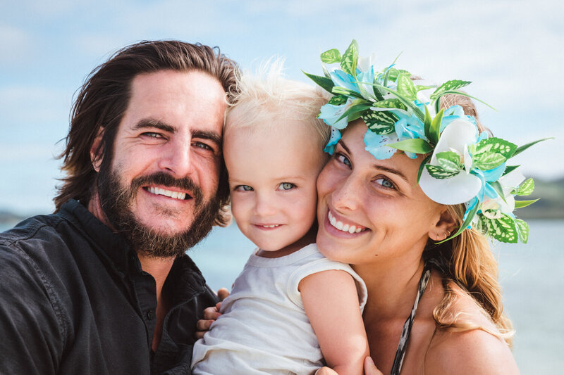 family with flowers on beach