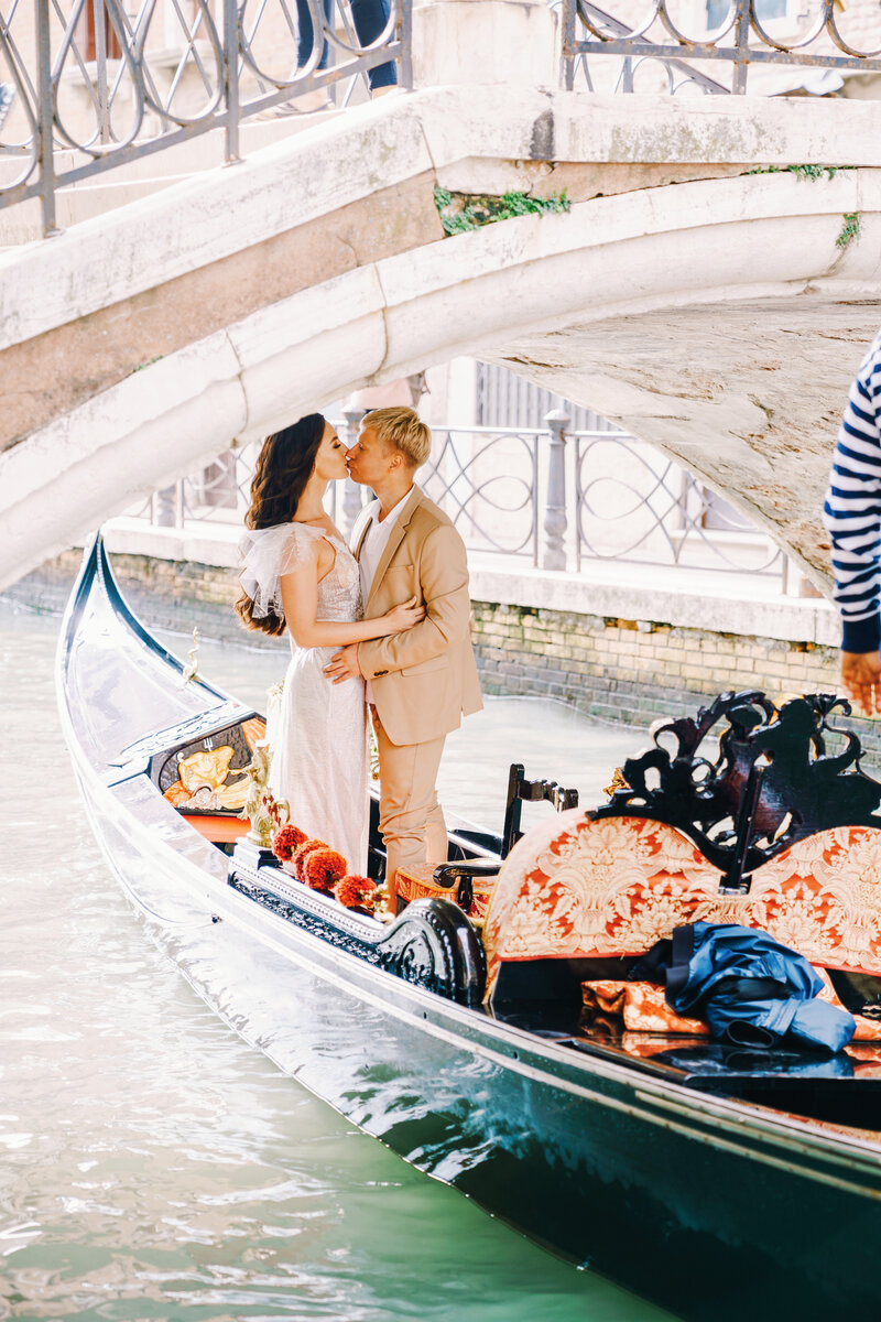 Bride Groom Engagement Session Gondola Venice under bridge kissing