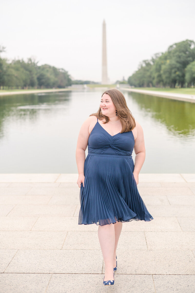 Law school grad smiles on the Reflecting pool during DC Graduation Session