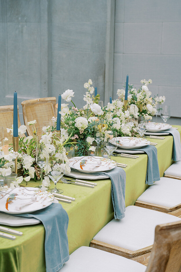 A table adorned with green and blue tablecloths, set for an Ohio garden wedding celebration.