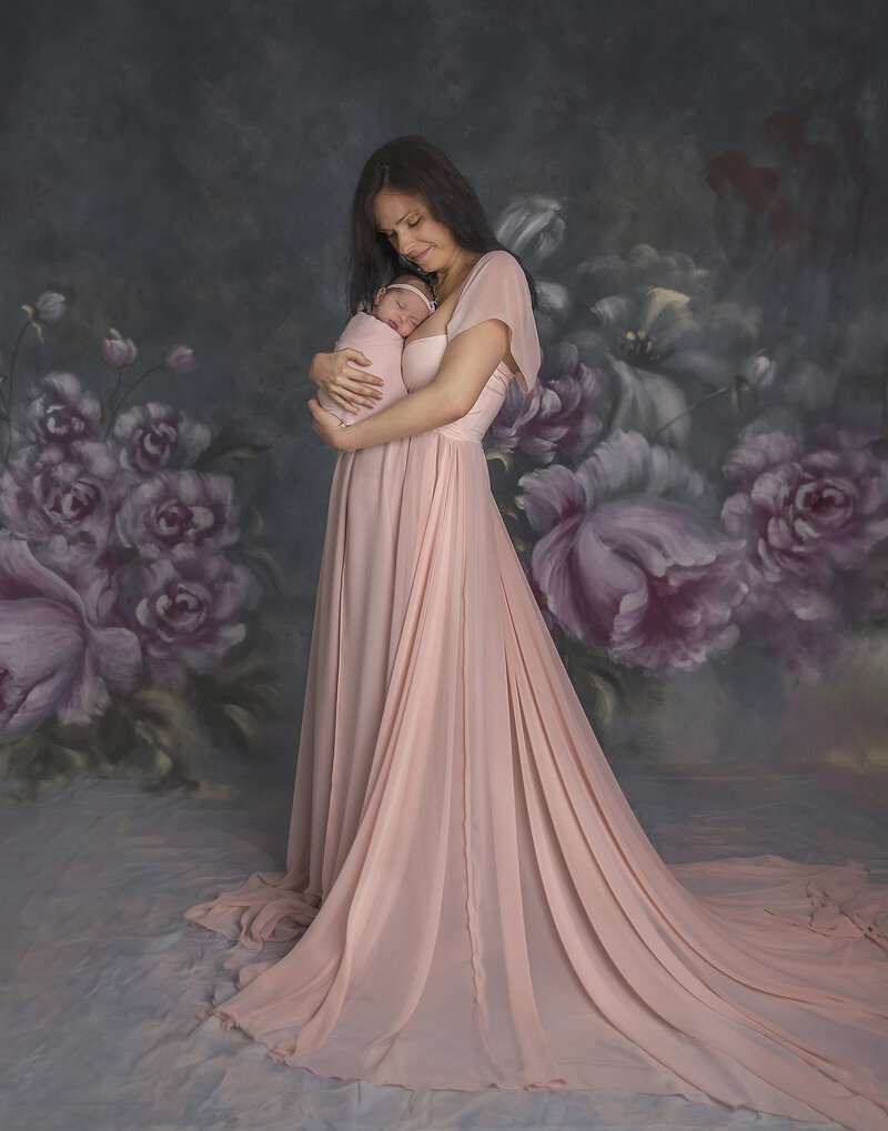 A beautiful moment of a mother holding her newborn baby in a stunning gown, captured in a timeless and elegant family portrait at Sonia Gourlie Fine Art Photography in Ottawa."